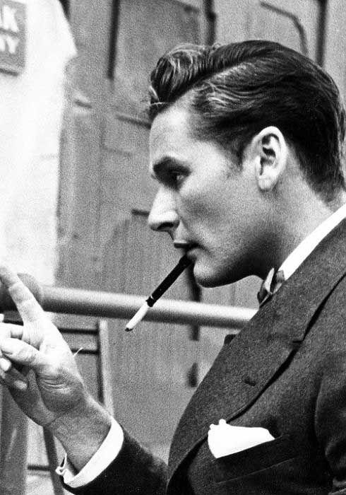 2) Su tupé voluminoso aporta un aire retro y sofisticado, complementando a la perfección la estética vintage del conjunto